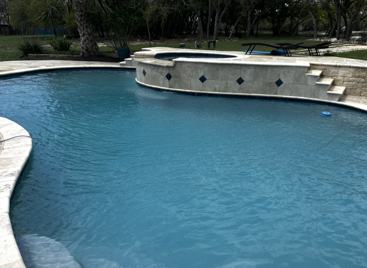 Waterline tile on a Bulverde pool where hard water leaves calcium scale